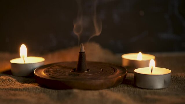 An incense cone burning and generating smoke.