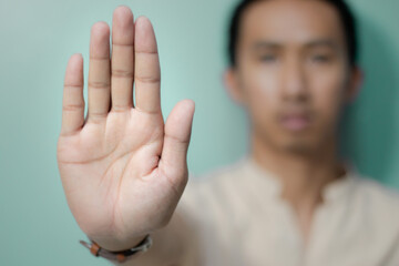 Man shows hand to stop or prohibit With a calm expression, the Asian man made a gesture, - obrazy, fototapety, plakaty