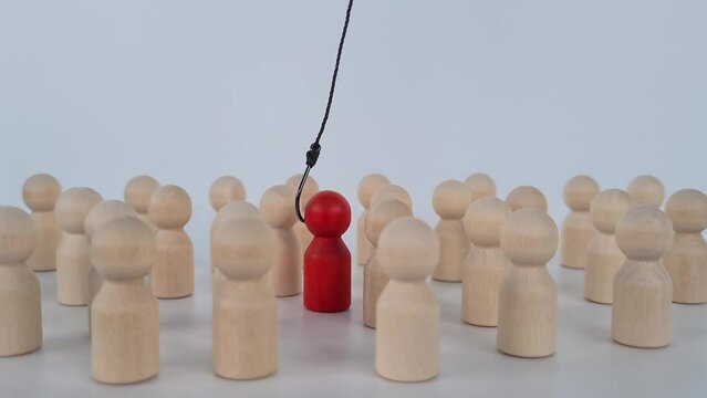 Hand with hook pulls red human figure out of crowd. Reveal disloyalty, repression and dissent