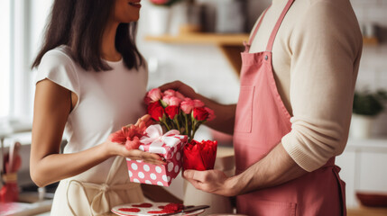 Couple in love in the kitchen exchanges homemade gifts in honor of Valentine's Day. A man and a woman spend time together at home. Concept of love, holiday.