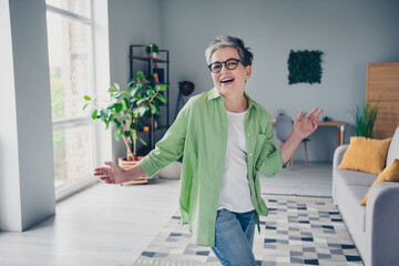 Photo of attractive overjoyed resting funny pensioner business woman dancing moving arms enjoying weekends after job indoors at home - obrazy, fototapety, plakaty