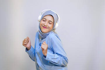  Cute young muslim woman enjoying music with headphone on. Enjoying music concept