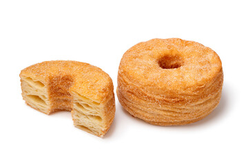 Whole and halved tasty sweet cinnamon Cronuts isolated on white background close up