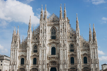 Milan Cathedral in summer, Italy. Nice view of ornate facade of the famous great Milan Cathedral. Historical gothic architecture of Milan. Top tourist attraction on piazza in the city