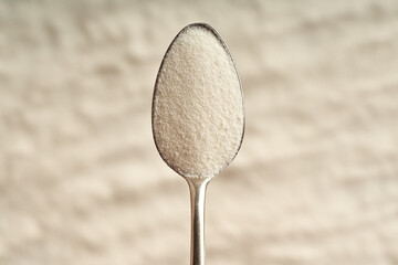 Collagen powder on a metal spoon