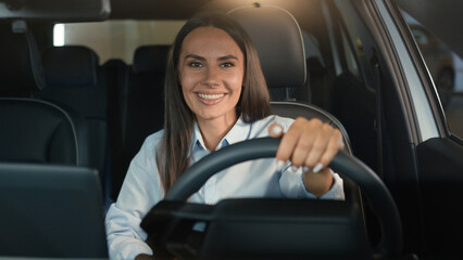 Obraz premium Caucasian woman girl female driver sitting in rental car inside in automobile smiling happy at camera driving enjoy buying new auto transport vehicle smile businesswoman rent service lady parking lot