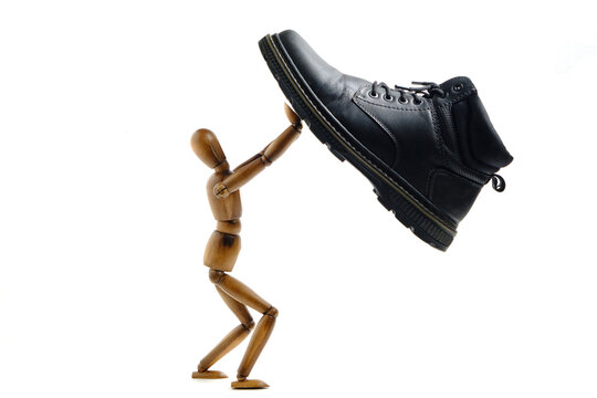 Mannequin detains and struggles with shoe that trying to crush it. Concept struggle and survival.