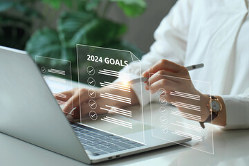 2024 New Year goals, plan, and action concepts. BusinessWoman using a laptop with a virtual goal...