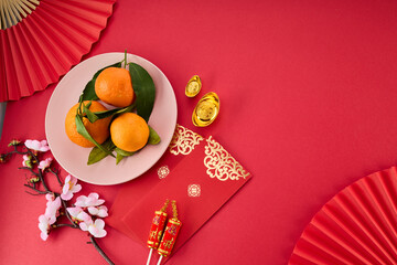 Chinese New Year. Red packet envelope, flowers, mandarins, festival decorations on red background....