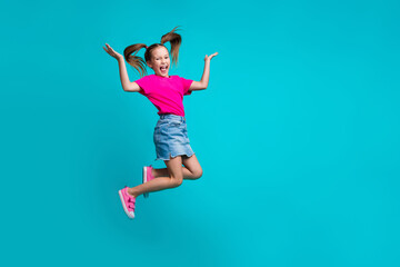 Fototapeta na wymiar Full size photo of optimistic girl dressed pink t-shirt skirt palms demonstrate offer empty space isolated on turquoise color background