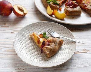 a piece of peach pie on a plate, light background, close-up without people