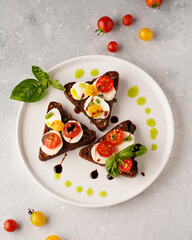 sandwiches with mozzarella and tomatoes and basil light background, close-up without people