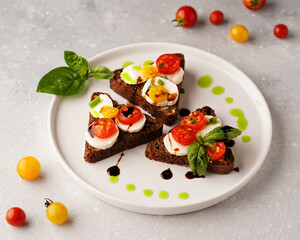 sandwiches with mozzarella and tomatoes and basil light background, close-up without people