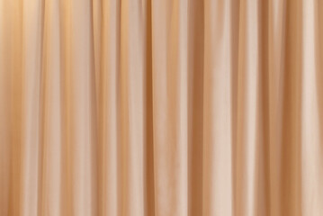 Peach fuzz color curtain that dropped down as a straight line. Background for inserting text, empty spaces.