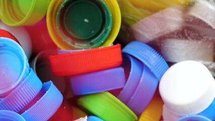 Lots of different colored plastic drink bottle caps in a designated recycling container, throwing away and collecting bottle caps for charity simple concept, nobody, macro detail closeup Eco lifestyle - Powered by Adobe