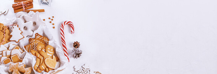 Top view of unpacked christmas present with sweets on a white textured surface, banner, close-up. Christmas celebration concept with space for text