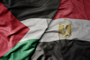 big waving national colorful flag of egypt and national flag of palestine .