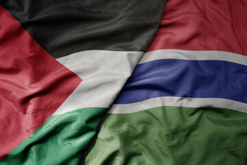 big waving national colorful flag of gambia and national flag of palestine .
