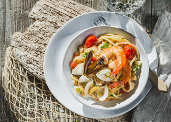 Plate of pasta spaghetti with seafood,  shrimps, clams, mussels tomatoes on healthy mediterranean food.