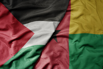 big waving national colorful flag of guinea bissau and national flag of palestine .