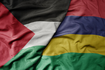 big waving national colorful flag of mauritius and national flag of palestine .