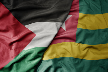 big waving national colorful flag of togo and national flag of palestine .