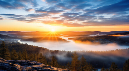 Sunrise over a misty mountain range in Finland, with the sun casting a golden glow on the peaks and mist in the valley.