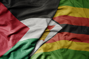 big waving national colorful flag of zimbabwe and national flag of palestine .