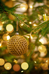 Christmas toy in gold color hanging on christmas tree. High quality photo