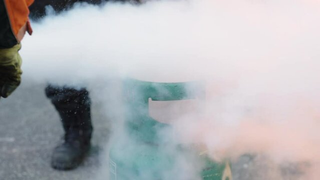 Firefighting drills from LPG combustion by experts. Man teaches or training how to use carbon dioxide (CO2) fire extinguishers to extinguish fires from fuel in house or industry for safety.