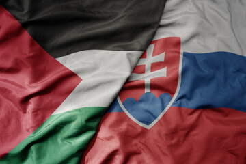 big waving national colorful flag of slovakia and national flag of palestine .