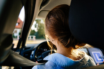 Rear view of young female with seat belt. American Teen Learning Driver's Education
