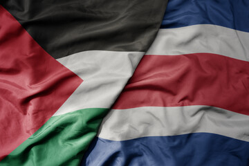 big waving national colorful flag of costa rica and national flag of palestine .