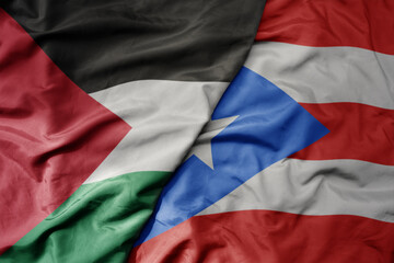 big waving national colorful flag of puerto rico and national flag of palestine .