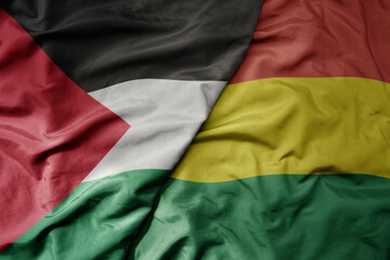 big waving national colorful flag of bolivia and national flag of palestine .