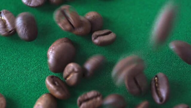 Close up of seeds of coffee. aromatic coffee beans fall on a green background.