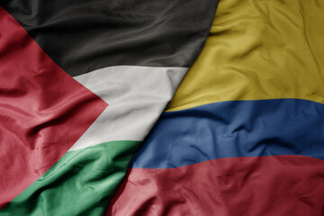 big waving national colorful flag of colombia and national flag of palestine .