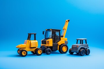 Toy forklift, asphalt paver and excavator on blue background