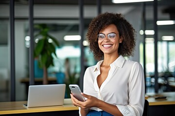 Happy business woman holding phone using cellphone in office. Smiling mature professional businesswoman executive using smartphone cell mobile apps on cellphone working sitting at desk. - obrazy, fototapety, plakaty