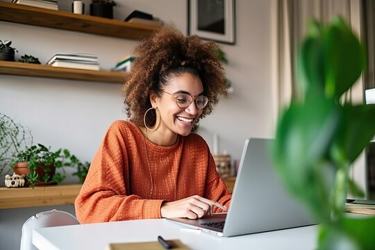 Happy young woman using laptop sitting at desk writing notes while watching webinar, studying online, looking at pc screen learning web classes, having virtual call meeting remote working from home. - Powered by Adobe