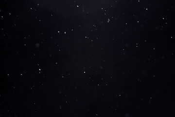 blurred winter snow background with flying snowflakes against black sky, texture for overlay and...