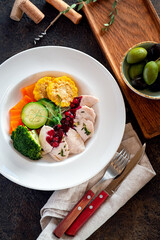 Steamed vegetables with chicken breast and cranberry sauce. Dietary food with a high protein content. Top view
