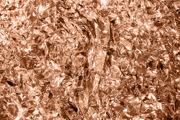 color of the year. Peach Fuzz.crumpled blue foil. abstract background from cut metallic paper.