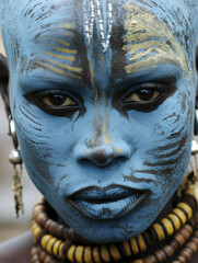 Close-up of black indigenous woman with her face completely painted. Indigenous tribe.