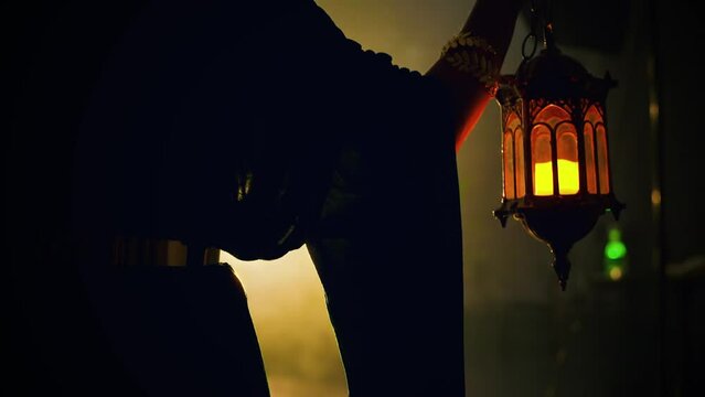 fantasy mystical woman back rear view walks in dark night full smoke holding lantern lamp in hand vintage old style. Gothic Girl in cape coat green dress hood on head, magic light candles art video 4k