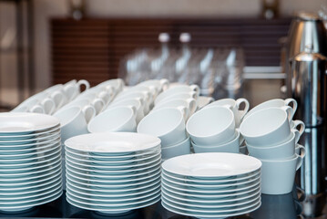 Set of empty clean white cups and plates, dishes