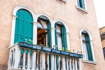 Fototapeta na wymiar A balcony on a traditional Venetian gothic building with a balcony and artistic glass flowers