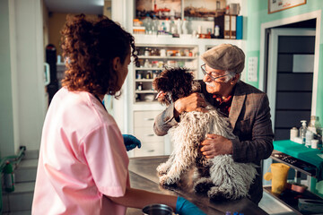 Senior man and pet dog with female veterinarian
