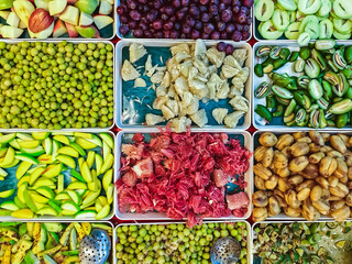 Top view of assorted fruits and pickled fruits on trays for sale in street market, healthy food concept Include high vitamin fruits, fresh fruits, Thai fruits, Street food.Variety fruits as background
