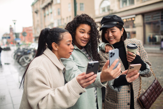 Young stylish women using smartphones in the city
